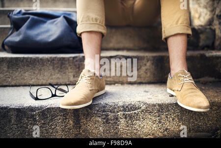 Détail de hipster moderne man's pieds assis sur l'escalier Banque D'Images