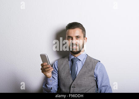 Studio shot of hipster moderne businessman using mobile phone Banque D'Images