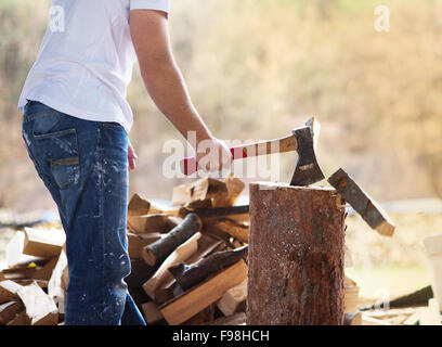 Détail de jeune homme couper du bois dans son arrière-cour Banque D'Images