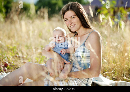 Heureux jeune mère s'amusant avec son fils dans la nature Banque D'Images