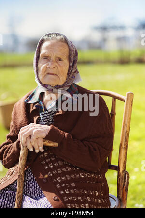 Très vieille femme avec foulard pour se détendre dans le jardin Banque D'Images