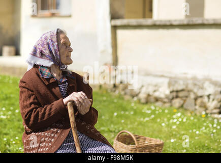 Très vieille femme avec foulard pour se détendre dans le jardin Banque D'Images