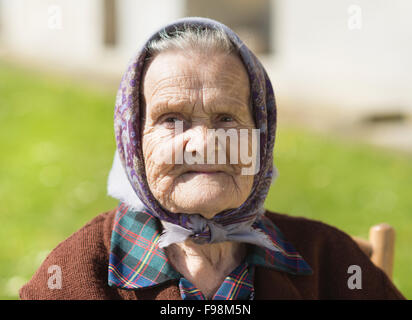 Très vieille femme avec foulard pour se détendre dans le jardin Banque D'Images