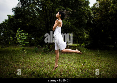 Une jeune vietnamienne portant tous les vêtements blancs au milieu d'un champ vert dans les régions rurales de Hanoi, Vietnam. Banque D'Images