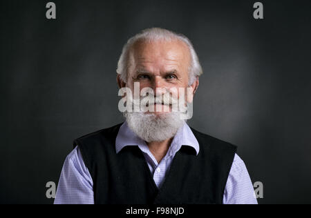 Portrait de vieux barbu, posant en studio sur fond noir Banque D'Images