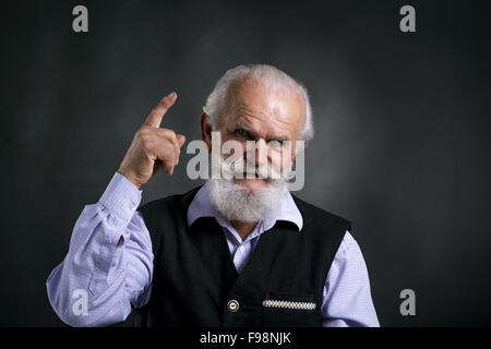 Portrait de vieux barbu, posant en studio sur fond noir Banque D'Images