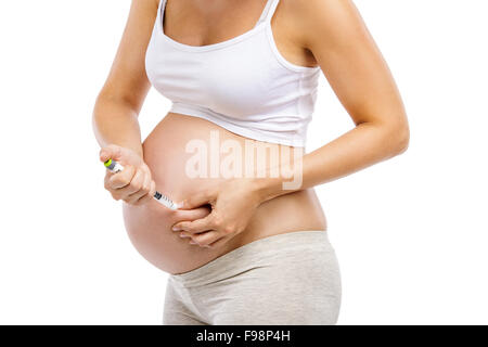 Méconnaissable femme enceinte avec la seringue dans la main isolé sur blanc, isolé sur fond blanc Banque D'Images