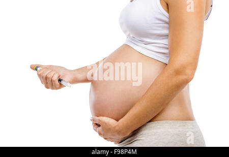 Méconnaissable femme enceinte avec la seringue dans la main isolé sur blanc, isolé sur fond blanc Banque D'Images