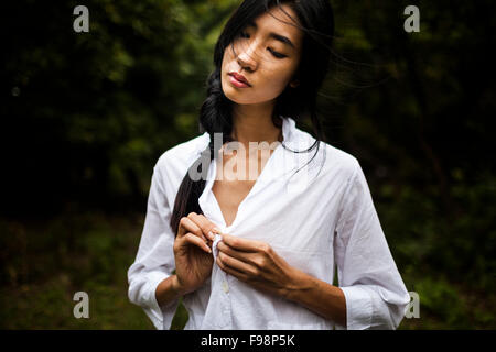 Une jeune vietnamienne portant tous les vêtements blancs au milieu d'un champ vert dans les régions rurales de Hanoi, Vietnam. Banque D'Images