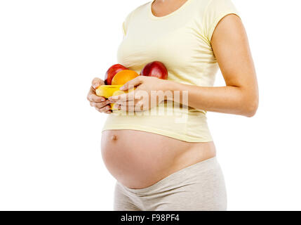 Méconnaissable pregnant woman holding fruit, isolé sur fond blanc Banque D'Images