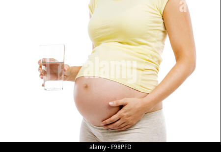 Méconnaissable pregnant woman holding glass of water, isolé sur fond blanc Banque D'Images