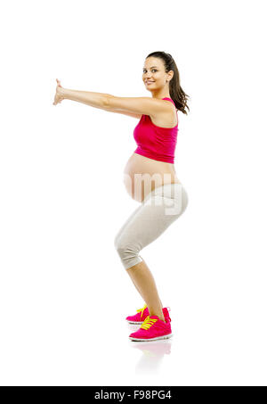 Portrait d'une belle jeune femme enceinte de faire les exercices, isolé sur fond blanc Banque D'Images