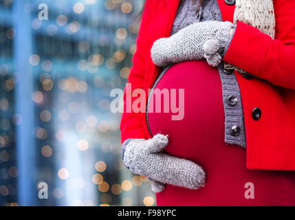 Détail de méconnaissable pregnant woman's belly en hiver à l'extérieur de la boutique de Banque D'Images