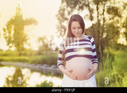 Portrait plein air de beautiful pregnant woman holding her belly Banque D'Images