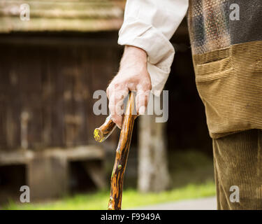 Close-up de vieux fermier avec stick marche dans sa cour arrière Banque D'Images