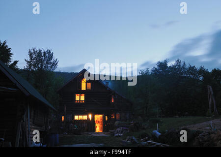 Maison de campagne en bois dans la nuit avec la lune et alléger l'exposition longue Banque D'Images