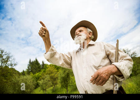 Vieux fermier avec barbe, travailler avec le râteau à jardin Banque D'Images