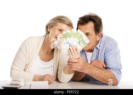 Senior couple comptant de l'argent à la table, isolé sur fond blanc Banque D'Images