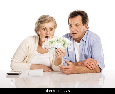 Senior couple comptant de l'argent à la table, isolé sur fond blanc Banque D'Images