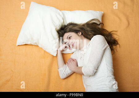 Belle femme est étendue sur le lit. Banque D'Images