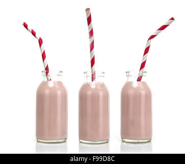 Trois bouteilles de lait rose avec rayures rouges et blanches sur fond blanc pailles Banque D'Images