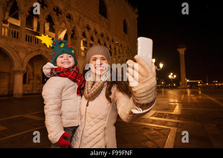 Maison de vacances famille voyage à Venise, Italie peut modifier l'ensemble de l'expérience de Noël. Heureuse Mère avec enfant prenant avec smart selfies Banque D'Images