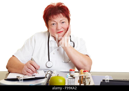 Female doctor sitting at desk et écoute avec attention Banque D'Images
