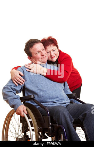 Femme âgée embrassant son homme handicapé en fauteuil roulant Banque D'Images
