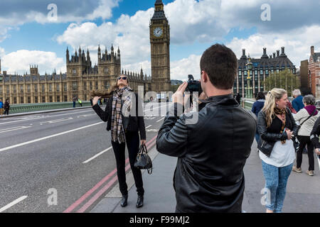 Les jeunes hommes qui prenaient des photos de belle femme en face de la Maison du Parlement, London, UK Banque D'Images