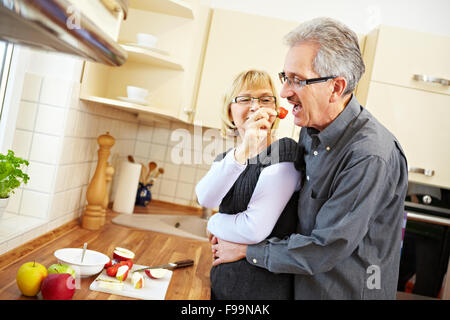 Femme âgée la préparation des fruits pour le muesli dans la cuisine Banque D'Images