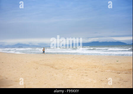 Handsome young Caucasian man walking alone avec sac à dos sur la plage Banque D'Images