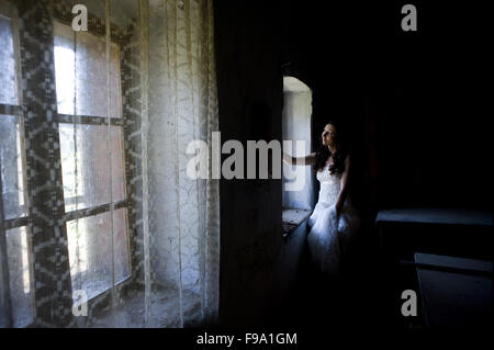 Belle et heureuse mariée brunette posing in old house Banque D'Images