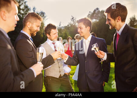 Marié avec quatre garçons heureux le brunissage à la réception de mariage à l'extérieur Banque D'Images