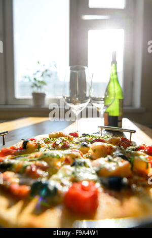 Close up photo de vert wineglasses vide bouteille de vin frais et pizza à la maison Banque D'Images