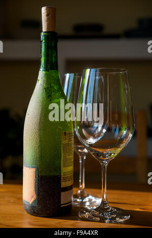 Close up photo de wineglasses vide et vert bouteille de vin à la maison Banque D'Images