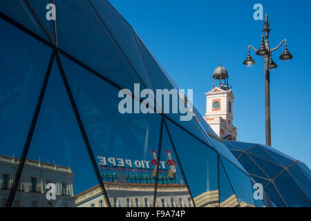 Tio Pepe en néon sur son nouvel emplacement, reflétée sur la façade en verre de Cercanias. La Puerta del Sol, Madrid, Espagne. Banque D'Images