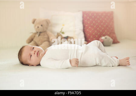 Bébé nouveau-né fille est allongée sur le lit Banque D'Images
