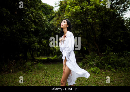 Une jeune vietnamienne portant tous les vêtements blancs au milieu d'un champ vert dans les régions rurales de Hanoi, Vietnam. Banque D'Images