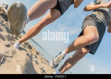 Voir les jambes d'un couple jogging en plein air, sur la plage Banque D'Images