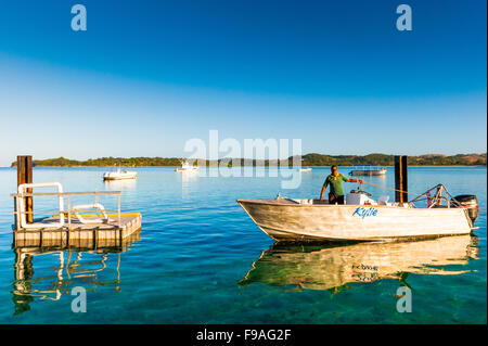 Un pêcheur apporte dans son bateau,tôt le matin sur Yanuca Island,Côte de Corail (Fidji). Banque D'Images