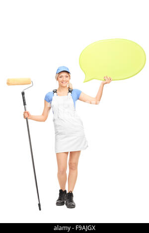 Portrait d'une femme peintre tenant un rouleau à peindre et une grande bulle jaune isolé sur fond blanc Banque D'Images