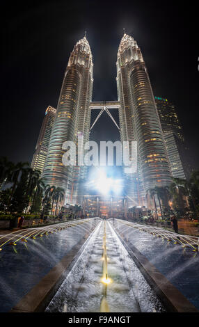 Fontaine en face des tours Petronas illuminé la nuit, Kuala Lumpur, Malaisie Banque D'Images