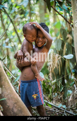 Jeune garçon, les Orang Asil, tenant son bébé qui pleure frère dans ses bras, la culture indigène, tropical rainforest Banque D'Images