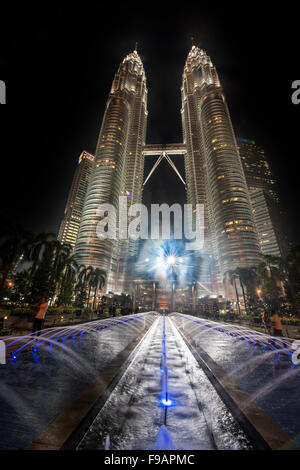 Fontaine en face des tours Petronas illuminé la nuit, Kuala Lumpur, Malaisie Banque D'Images