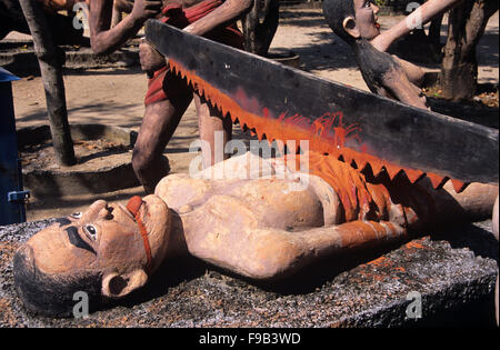 Sculptures en béton de la punition et torture de la pécheur ou du criminel masculin, en étant Sawn dans la moitié, pour voler, chmangeant ou détruire la propriété. Kitsch Folk Art Sculpture in the Wat Wang Saen Suk Hell Garden in the Temple Grounds, Bang Saen, Chonburi Thaïlande Banque D'Images