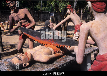 Sculptures en béton de la punition et torture de la pécheur ou du criminel masculin, en étant Sawn dans la moitié, pour voler, chmangeant ou détruire la propriété. Kitsch Folk Art Sculpture in the Wat Wang Saen Suk Hell Garden in the Temple Grounds, Bang Saen, Chonburi Thaïlande Banque D'Images