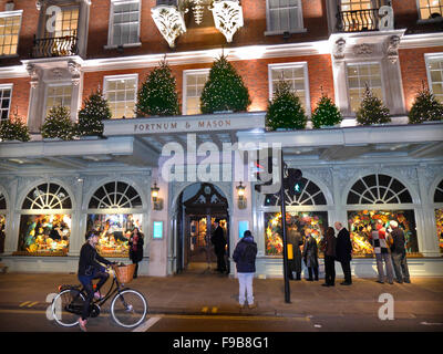 Magasin Fortnum & Mason à Noël, l'entrée éclairée la nuit de fête avec des décorations de Noël et les arbres London UK Banque D'Images