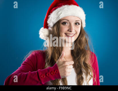 Portrait de jolie femme isolé sur bleu, studio shot in christmas hat Banque D'Images