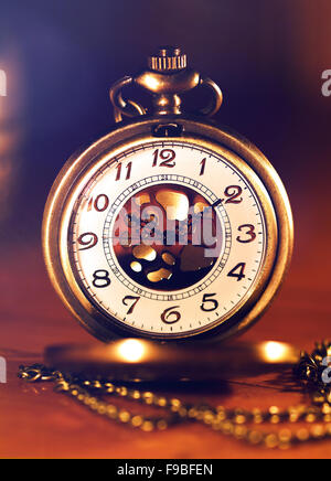 Retro montre en or en belle lumière bougie sur fond brun Banque D'Images