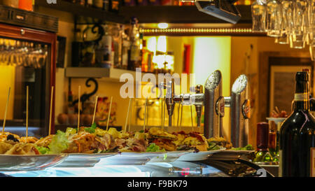 Table supérieure en bar à tapas espagnol avec sélection de pompes à bière, des aliments et des verres, Close up. Banque D'Images